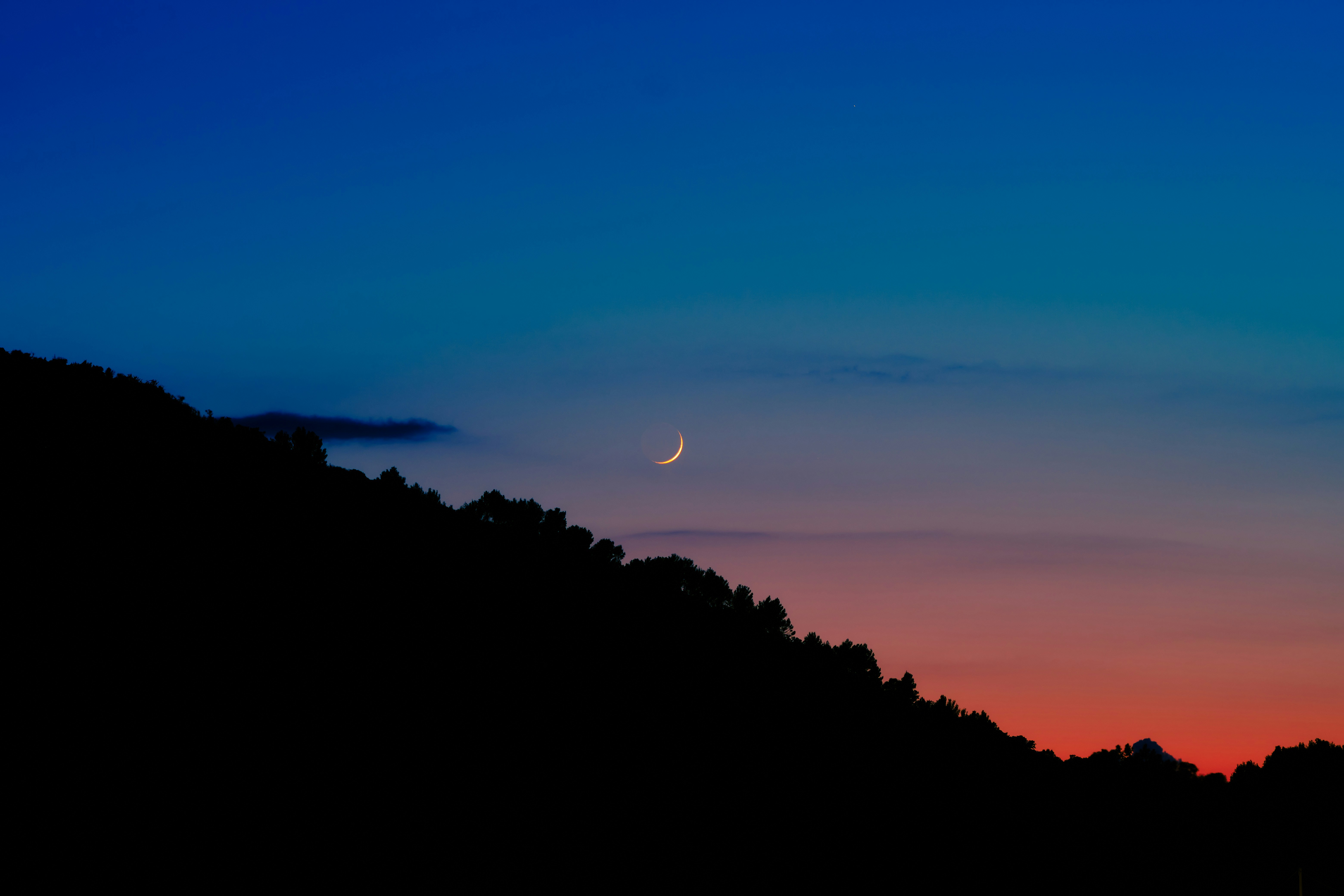 a moon in the sky, sunset moon