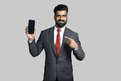 a man in a suit holding a phone up to his ear