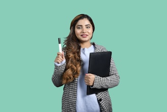 a woman holding a pen and a notebook