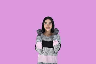 A young woman smiling confidently while wearing a soft, comfortable sweater from femme favs collection.