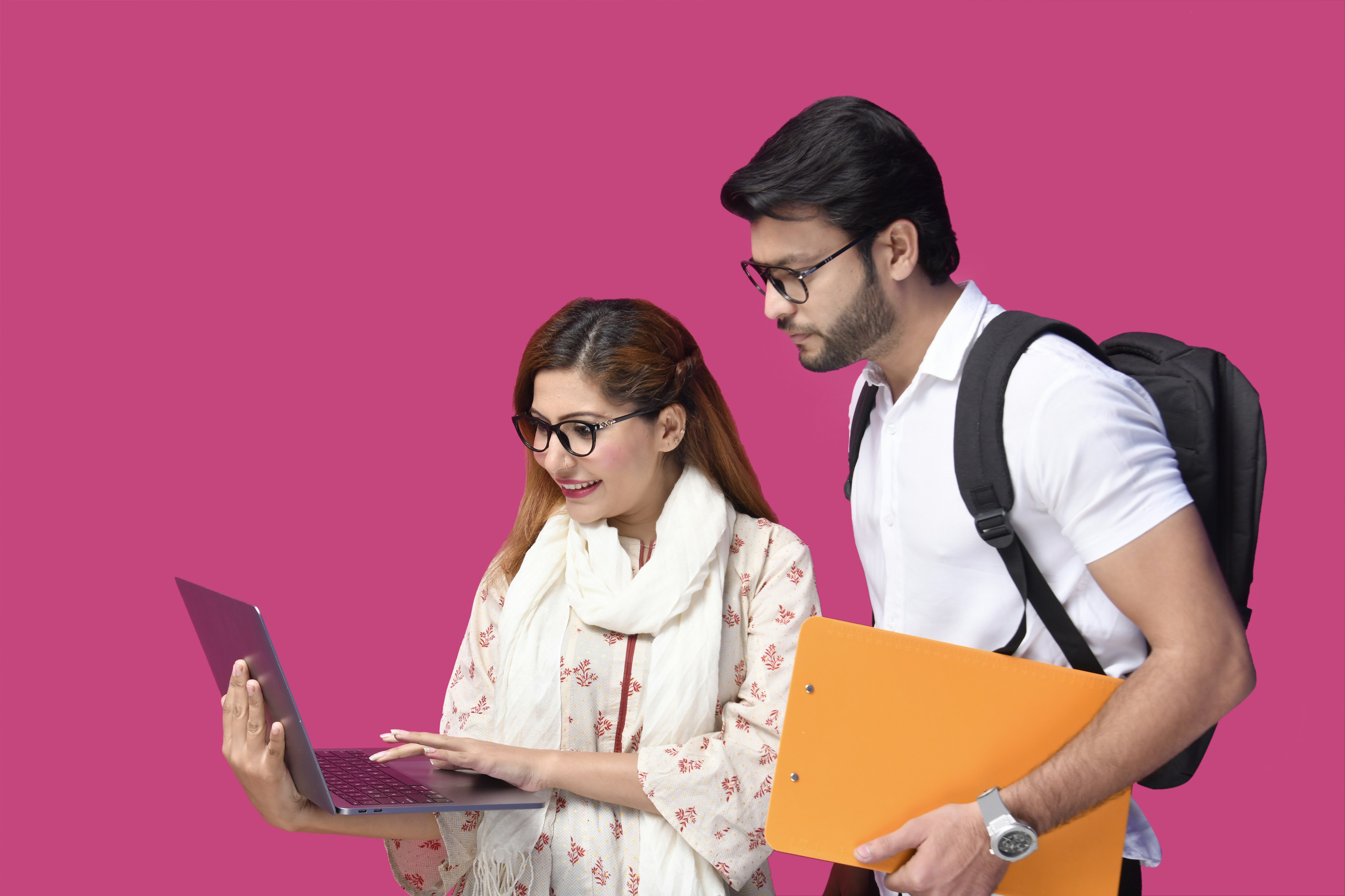 a man and a woman looking at a laptop