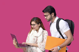 a man and a woman looking at a laptop