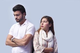 a man and a woman standing next to each other and looking at the camera
