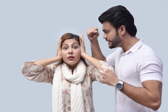 a man and a woman with their hands up