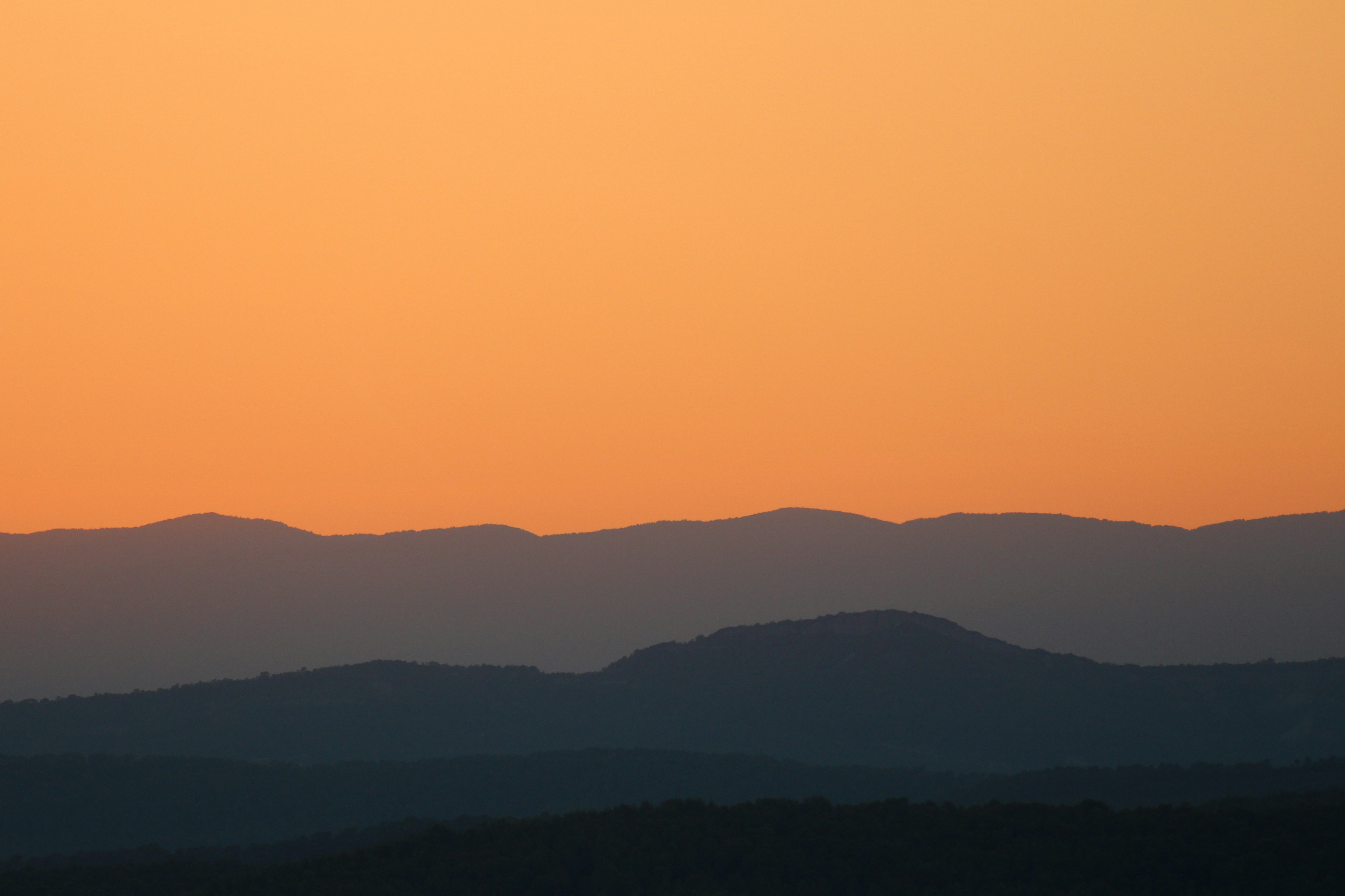 a landscape with hills and a sunset