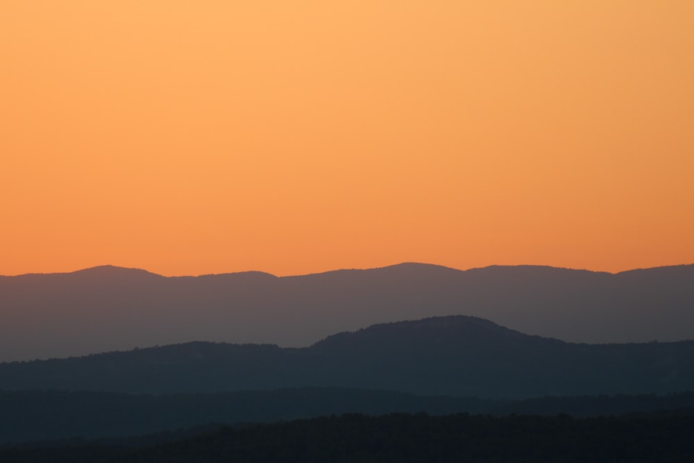 a landscape with hills and a sunset