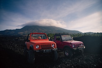 two red trucks parked on a hill