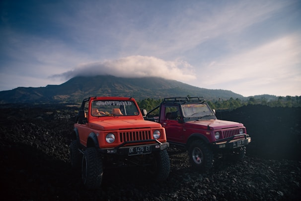 two red trucks parked on a hill