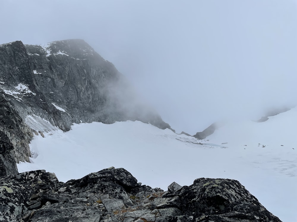 a snowy mountain with a foggy sky