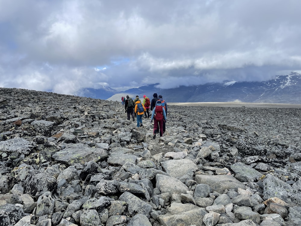 a group of people walking on a rocky terrain