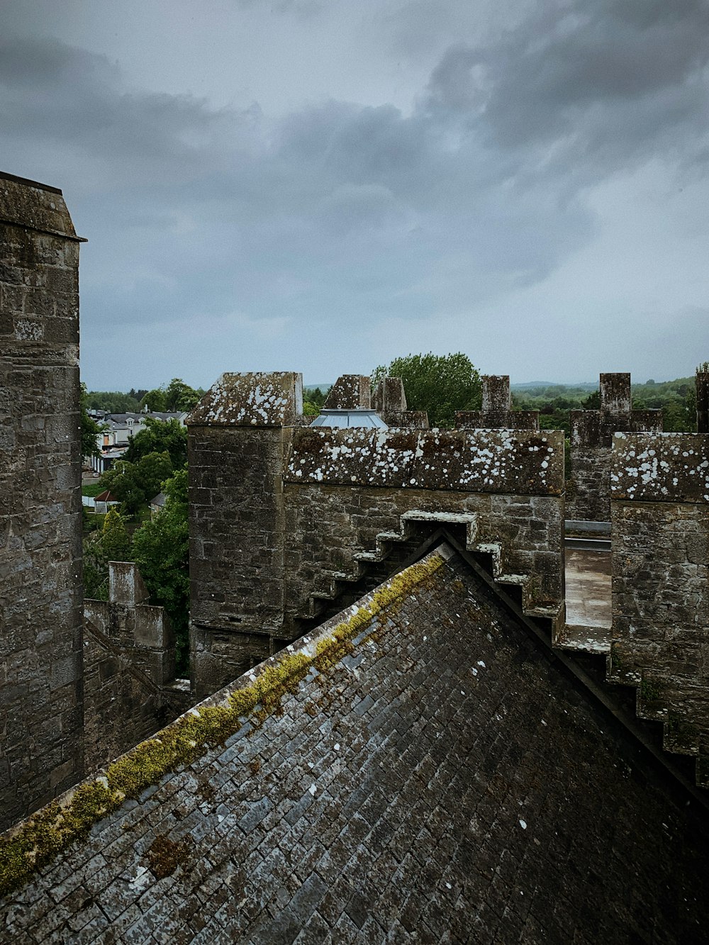 a stone wall with a stone fence and a city in the background