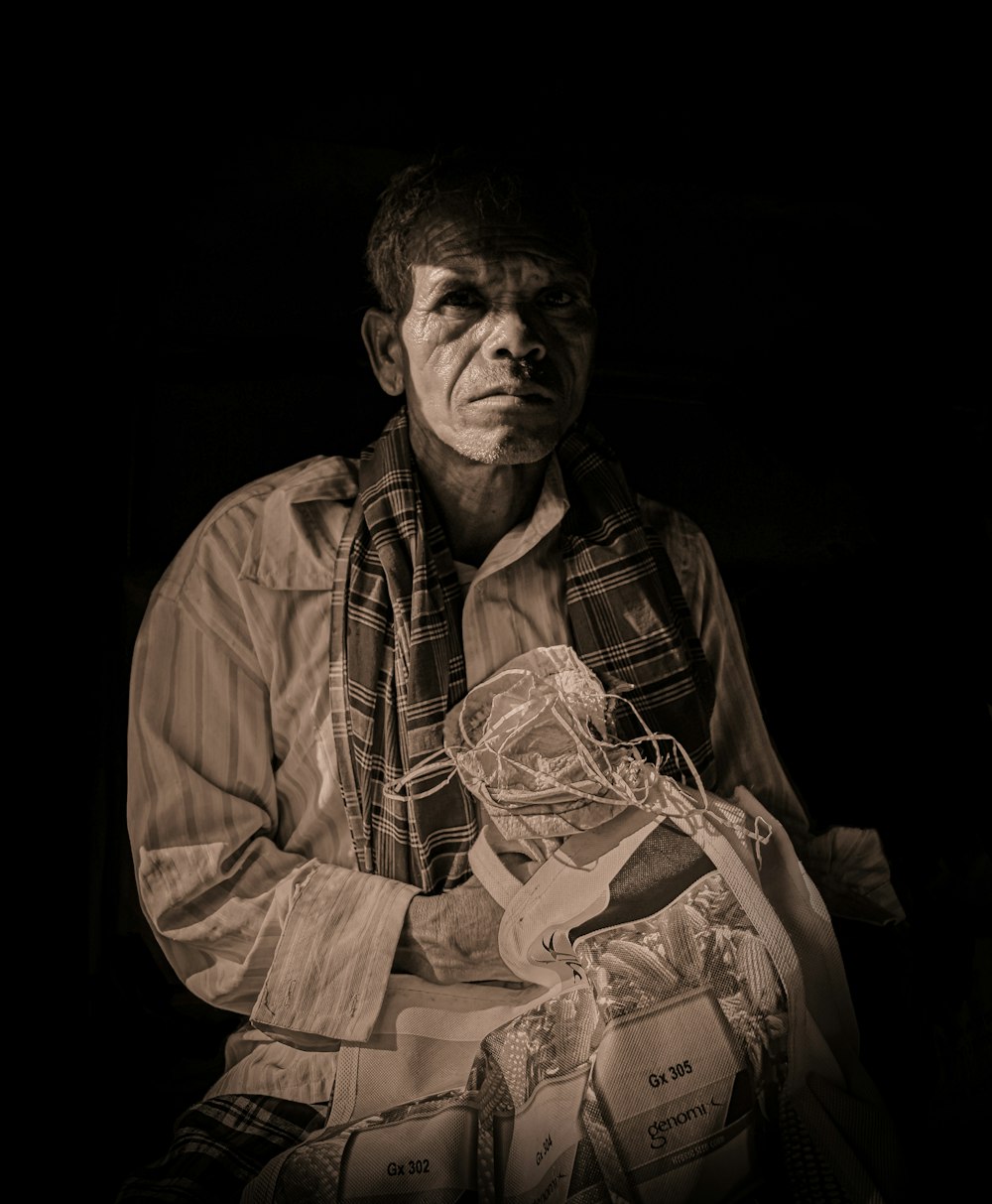 a man sitting and holding a fan