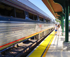 a couple of women walking on a platform next to a train
