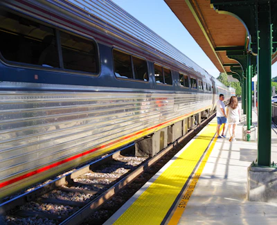 a couple of women walking on a platform next to a train