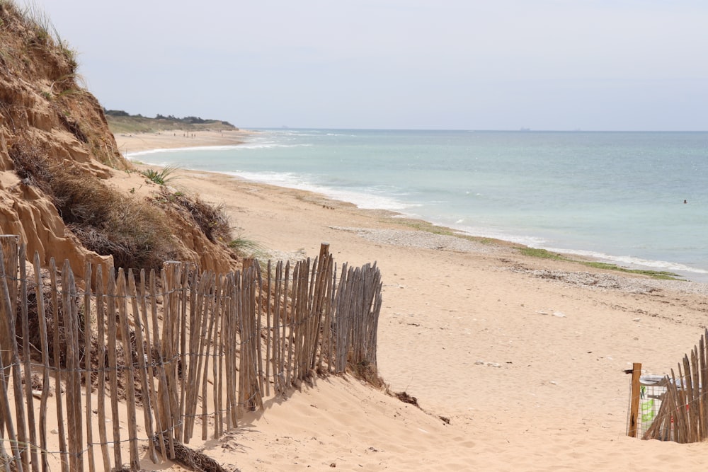 a sandy beach with a fence