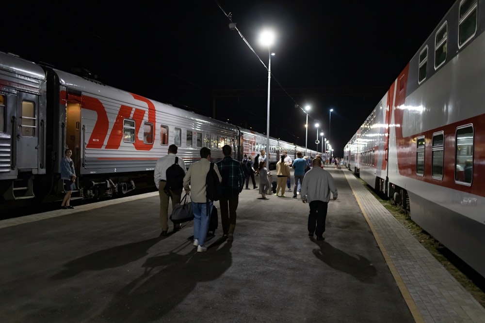 people walking on a platform next to a train