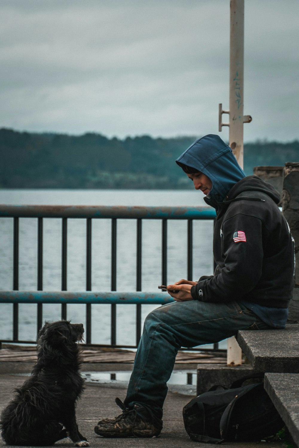 a person sitting on a bench next to a dog