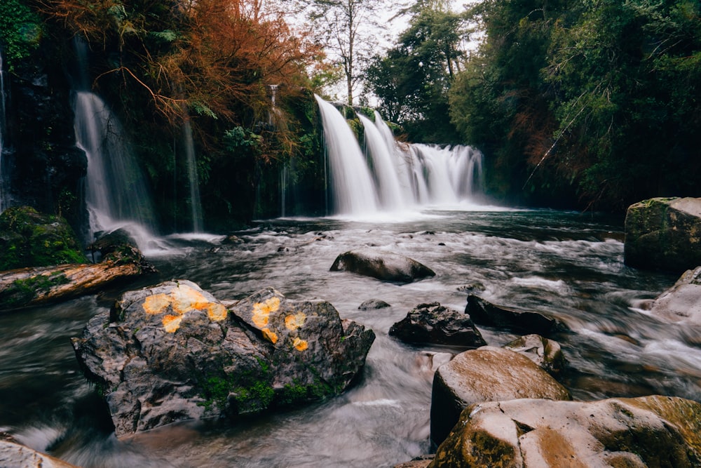 a waterfall with rocks and trees