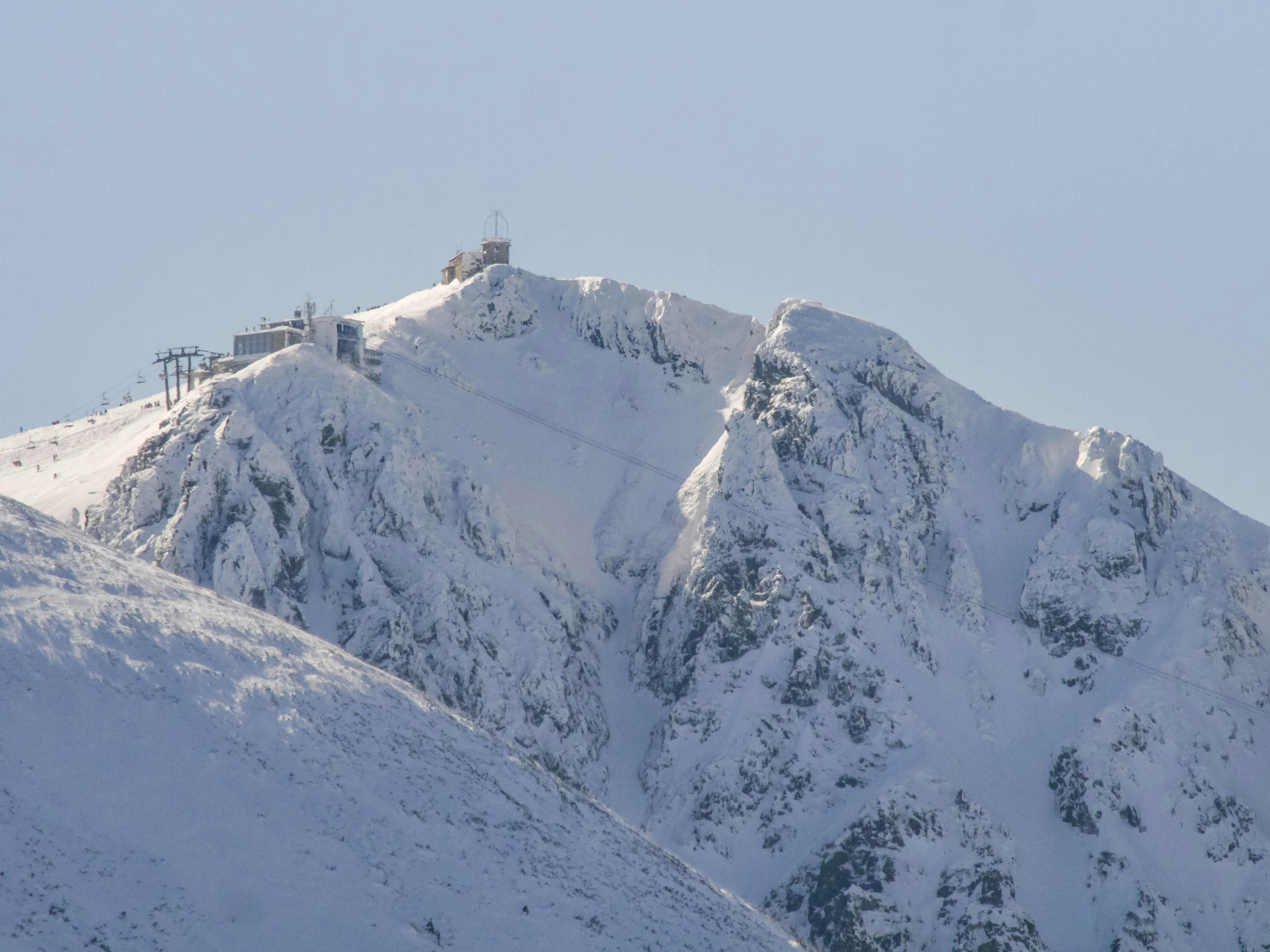 a snowy mountain with a building on top