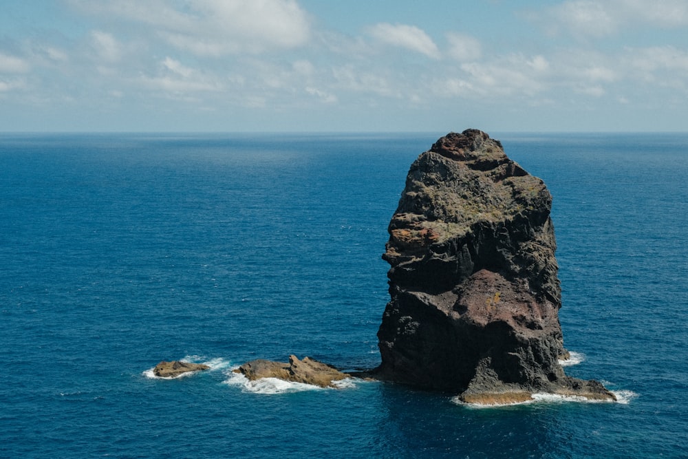 a large rock in the middle of the ocean