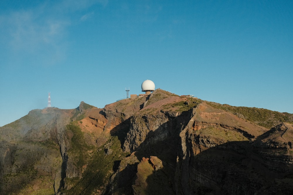 a mountain with a white satellite dish on top