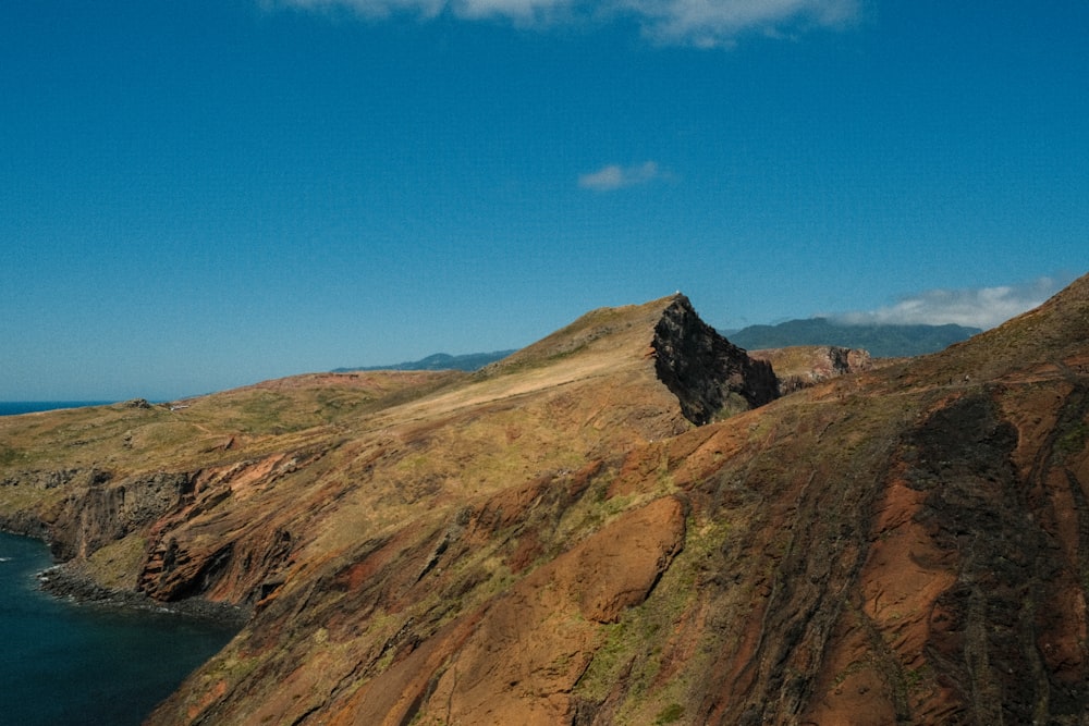 a rocky mountain next to a body of water