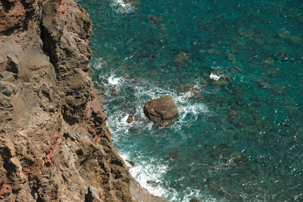 a rocky beach with a body of water in the background