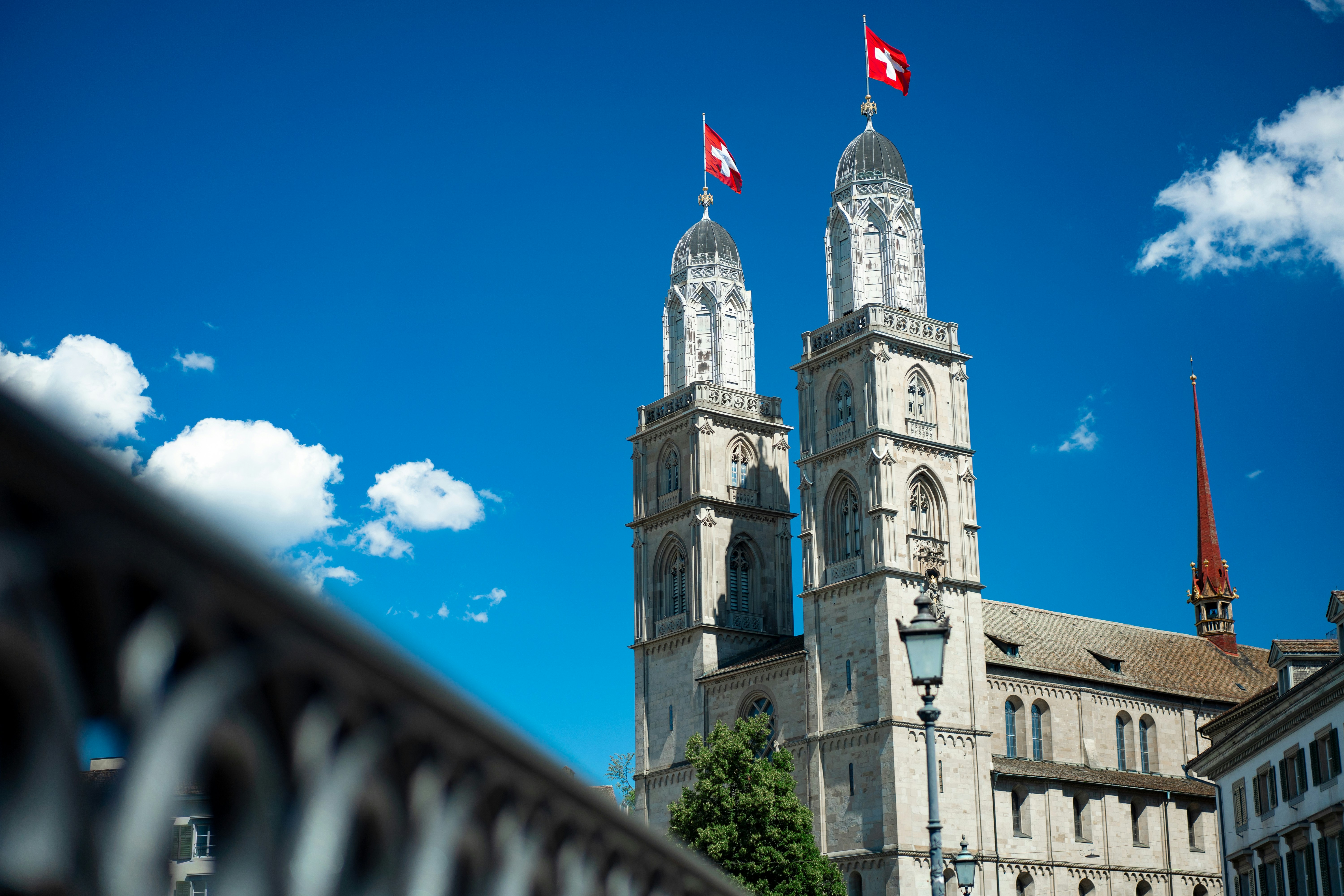a building with a tower and flags on top (Photo by Alin Andersen on Unsplash)