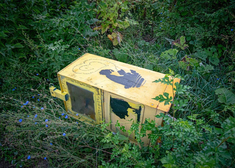 a yellow house in the middle of a forest