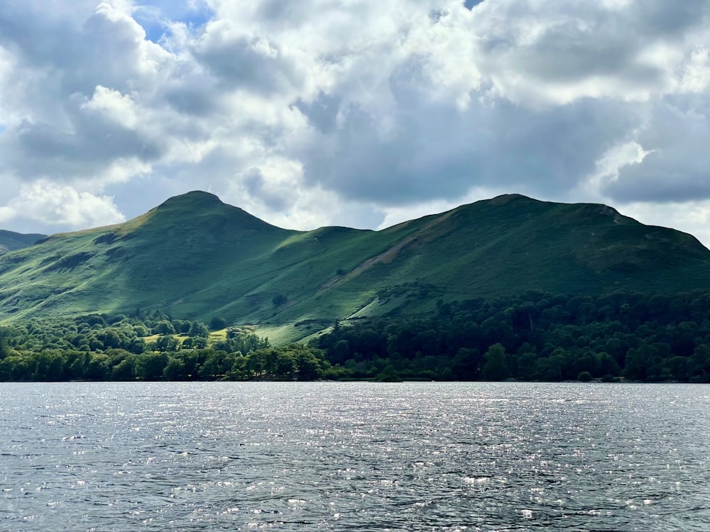 a body of water with trees and mountains in the background