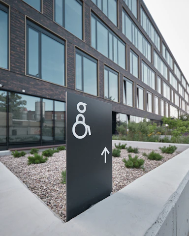 A bright, inviting entrance with a wheelchair ramp and inclusive signage welcoming all guests.