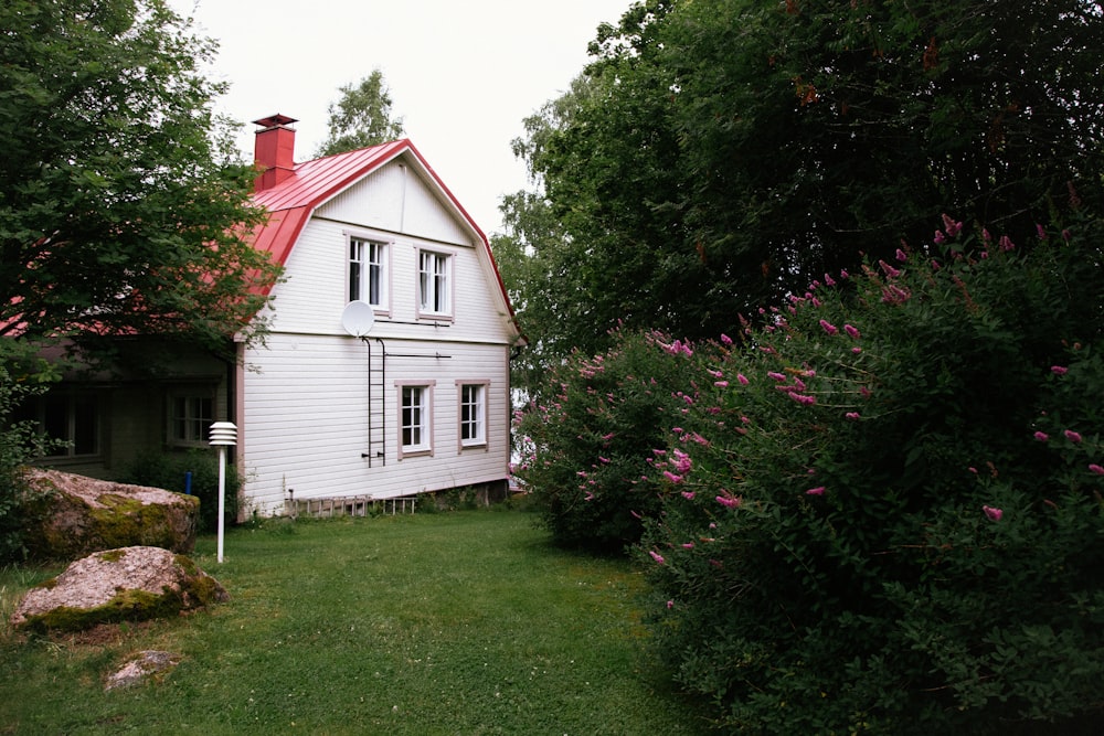 a house with a yard and bushes around it