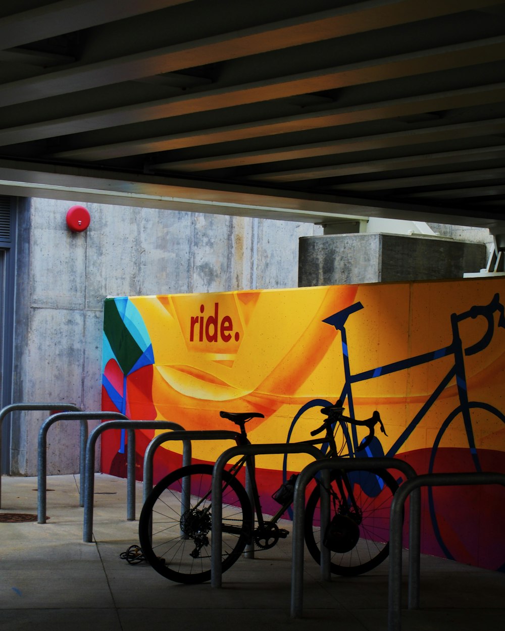 a bike parked next to a wall with graffiti