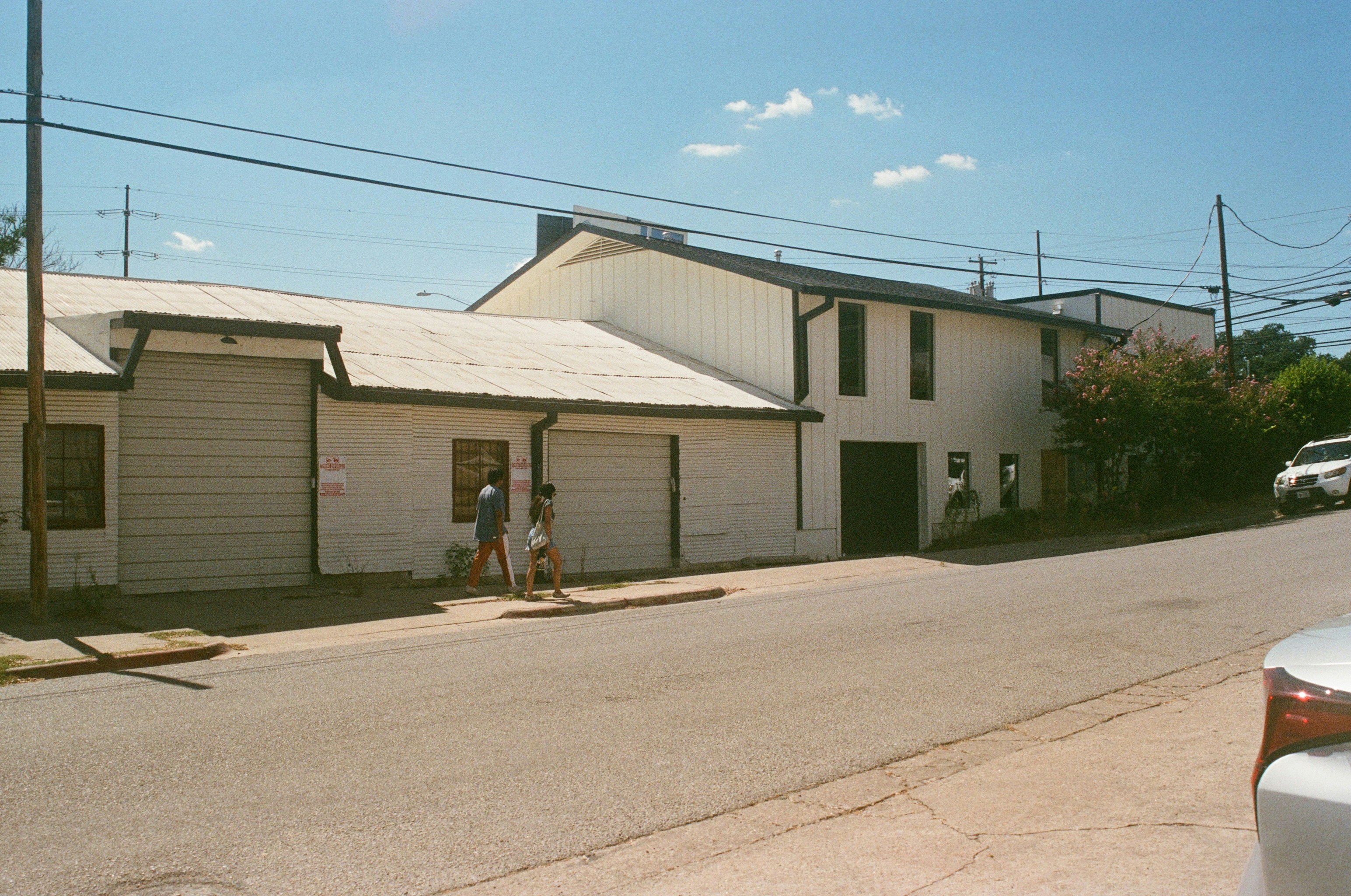 a couple of people walking down a street next to a building