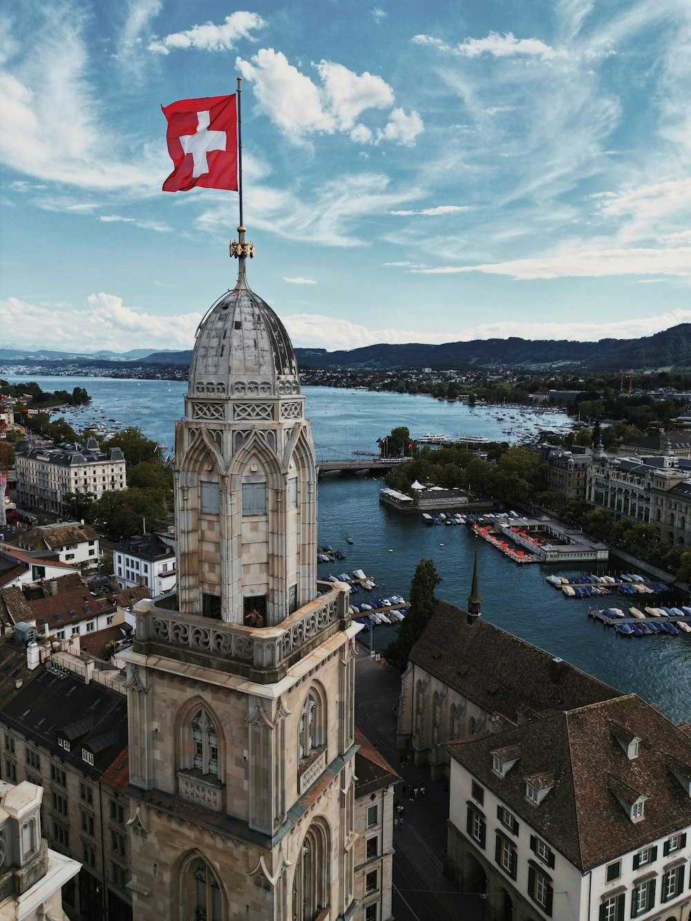 a large building with a flag on top and a body of water in the background