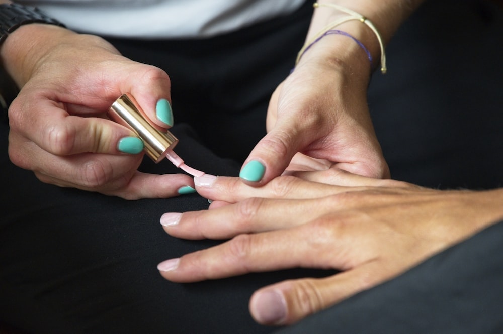 a person's hands with painted nails