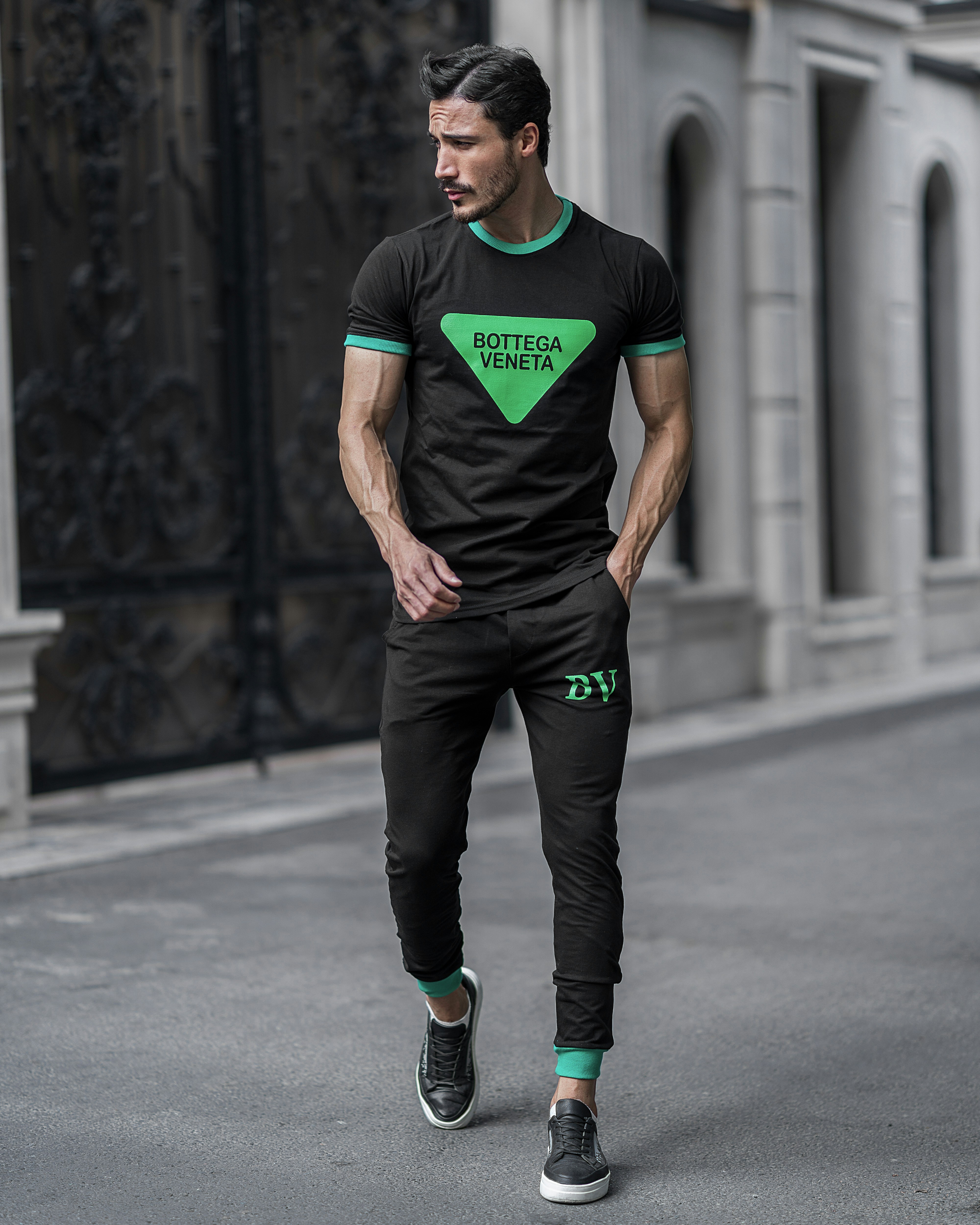 a man wearing a green shirt and black pants