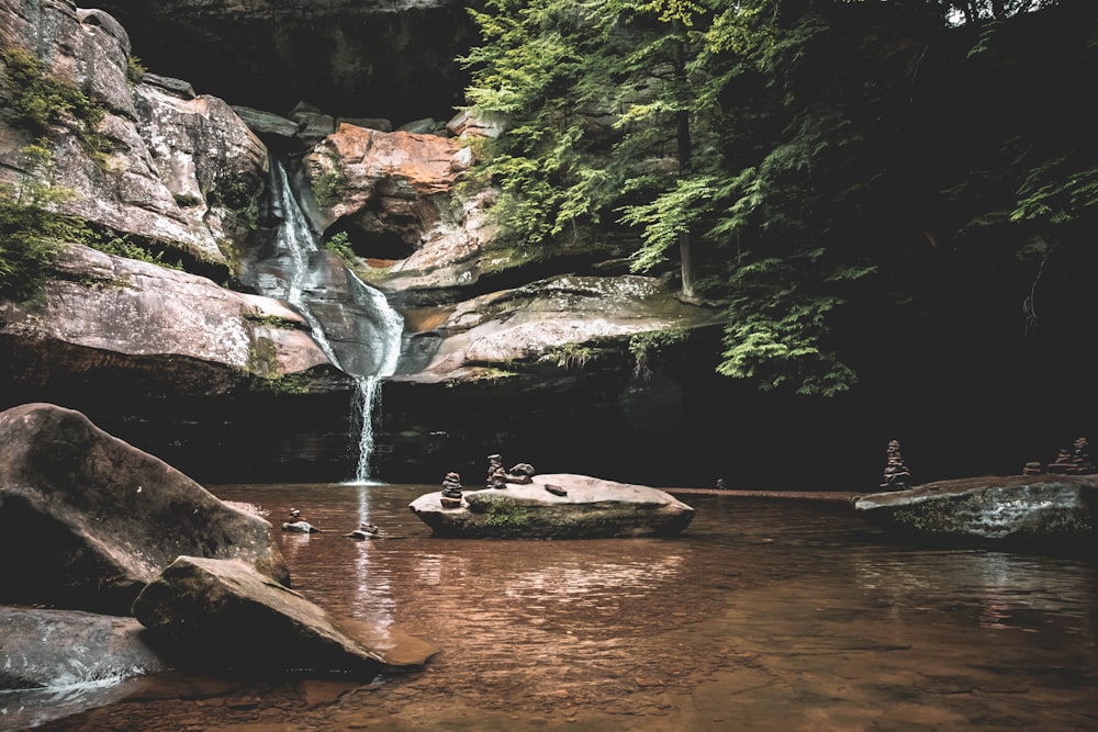 a group of people sitting on rocks in a river