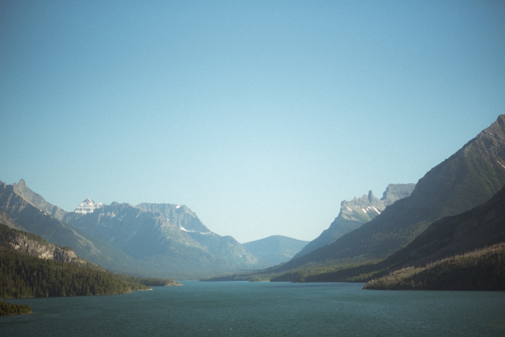 a body of water with mountains in the back