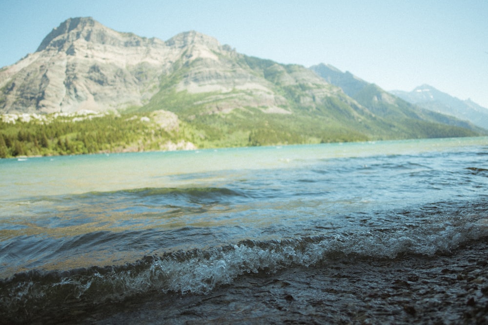 a body of water with a mountain in the background