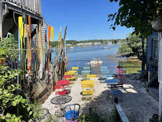 A charming outdoor seating area beside the river, with comfortable chairs and gentle greenery.