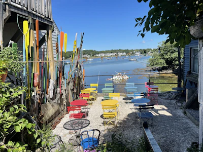 A charming outdoor seating area beside the river, with comfortable chairs and gentle greenery.