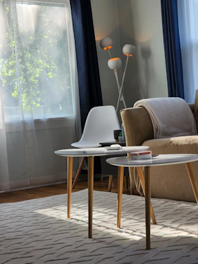 A modern living room corner with a sleek lamp and a soft throw blanket draped over a comfy chair.