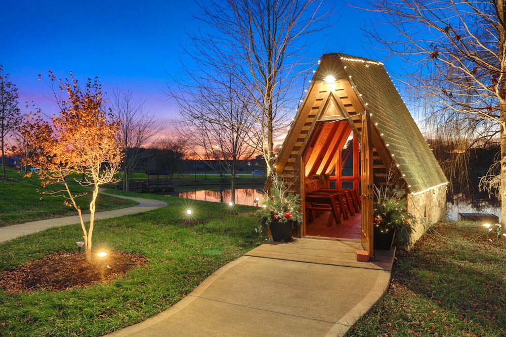 a wood house with a walkway and grass and trees