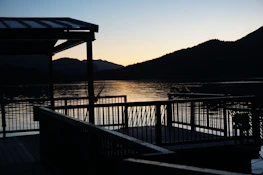 Guests enjoying a peaceful moment on a private deck overlooking a calm river at dusk.