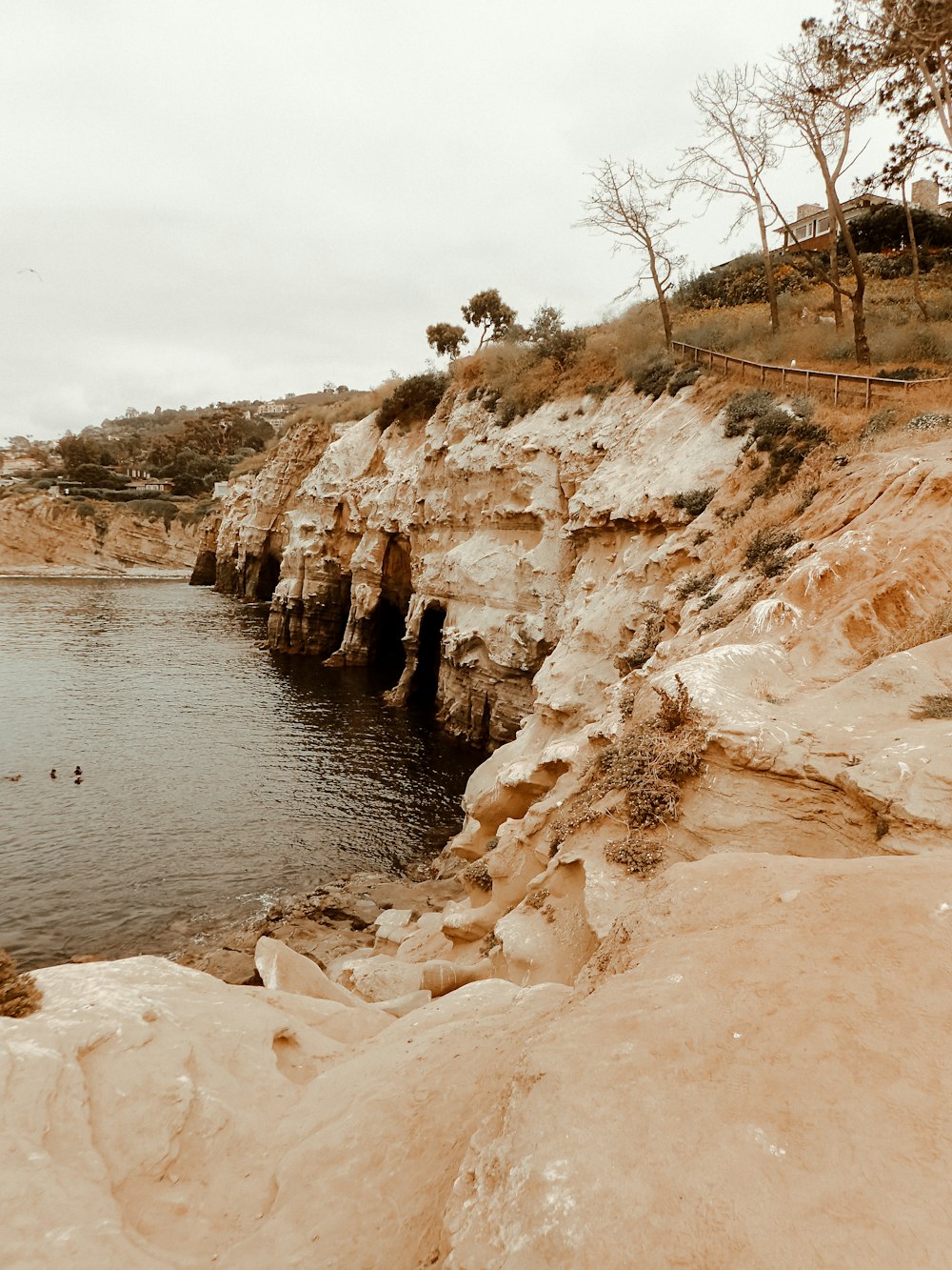 a rocky cliff next to a body of water