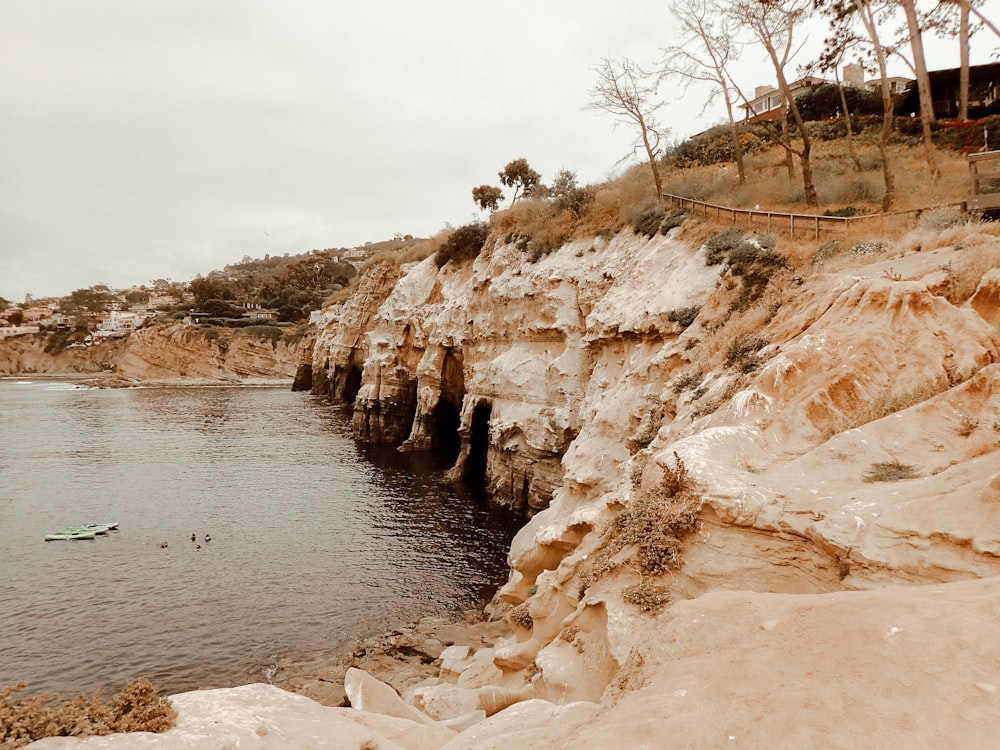 a rocky beach with a body of water and a boat