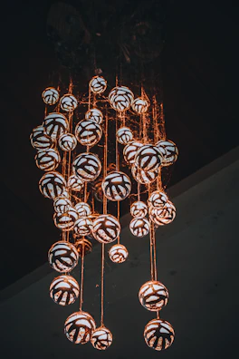 A cluster of lantern-style ceiling lights casting intricate shadows on a festive wall.