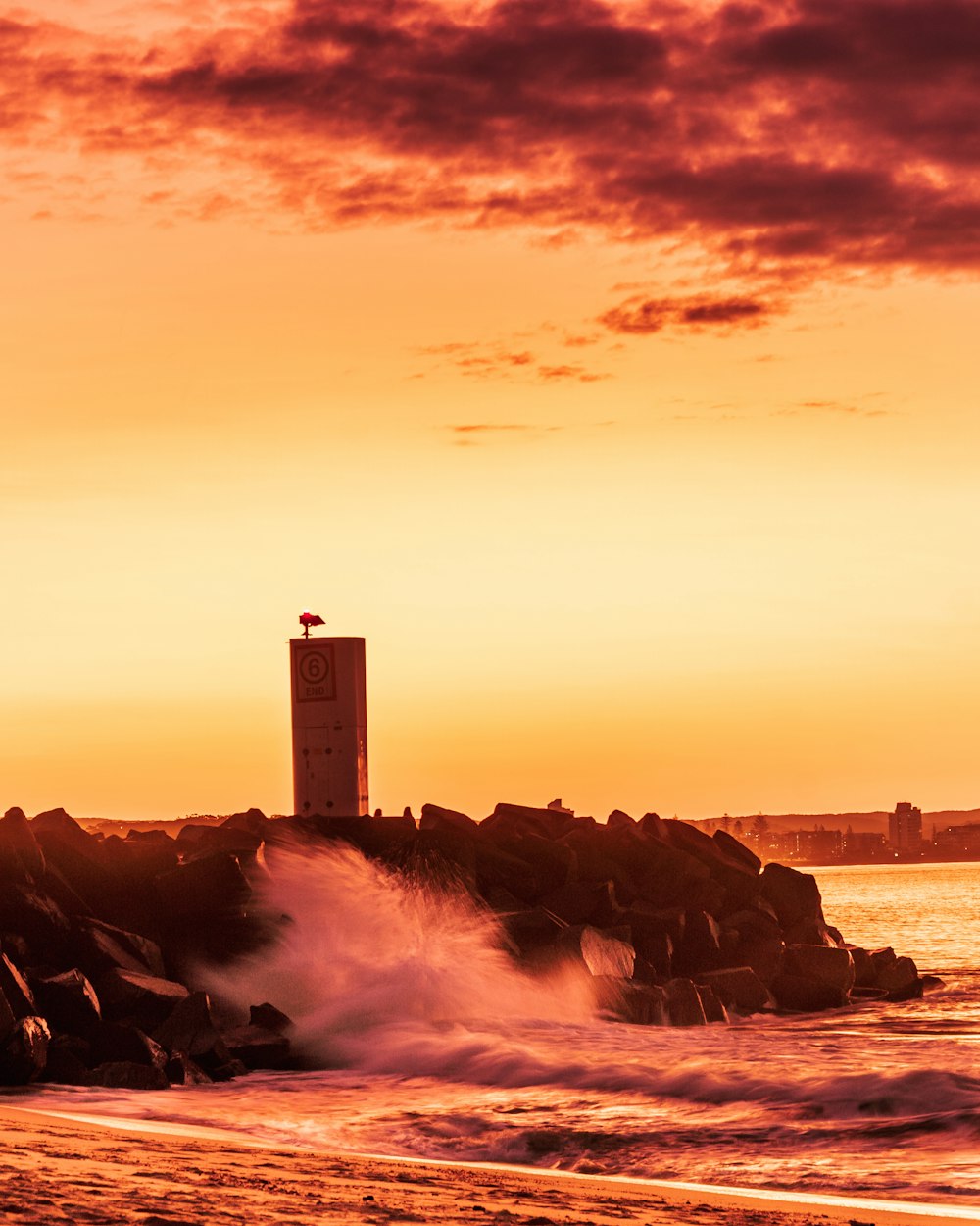 a clock tower on a rocky beach