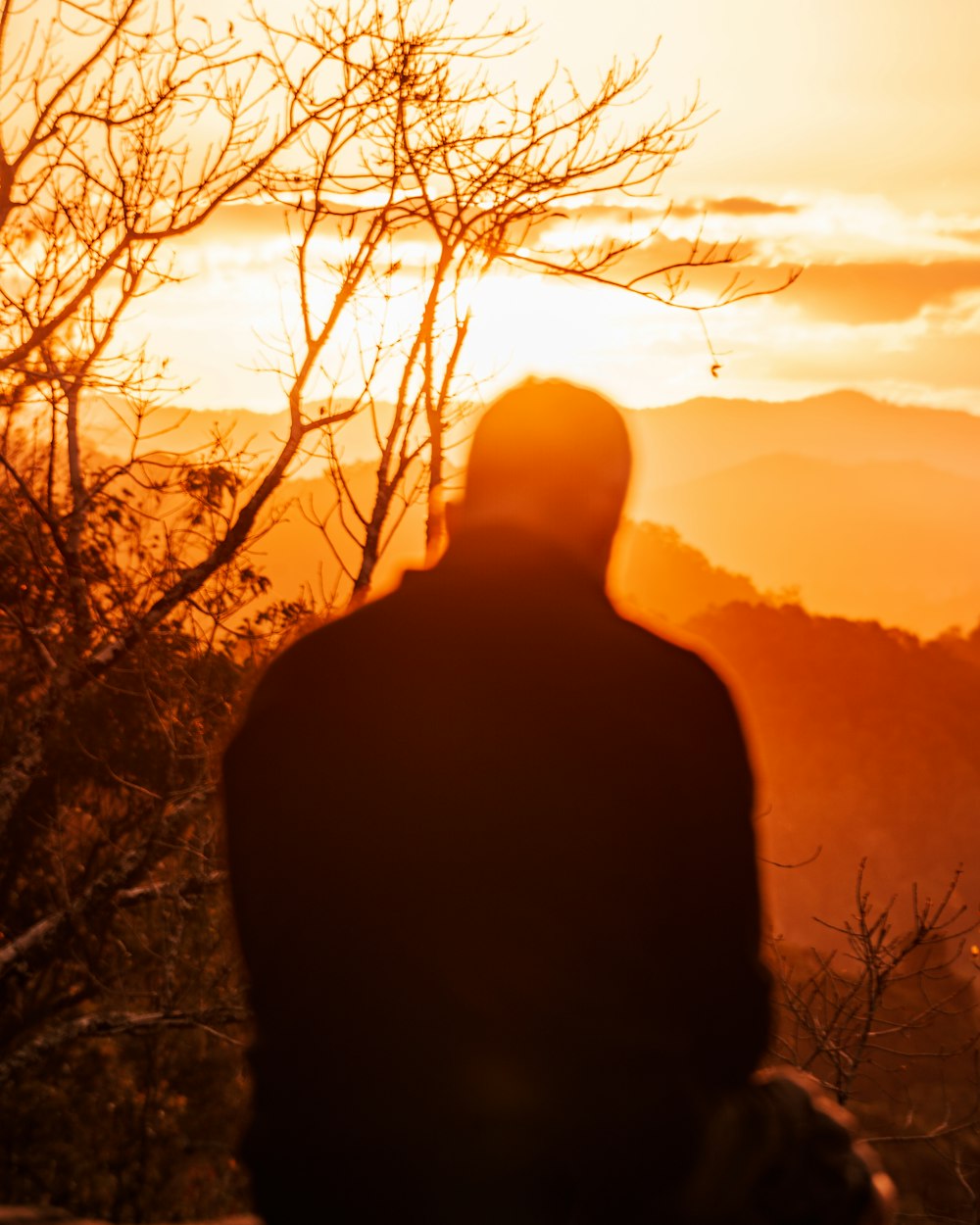 a person standing in front of a sunset